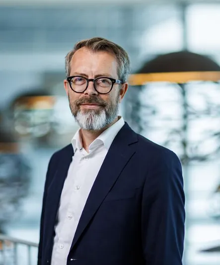 Elise Letmolie Ramse lener seg over gelender og ser inn i kamera med et smil