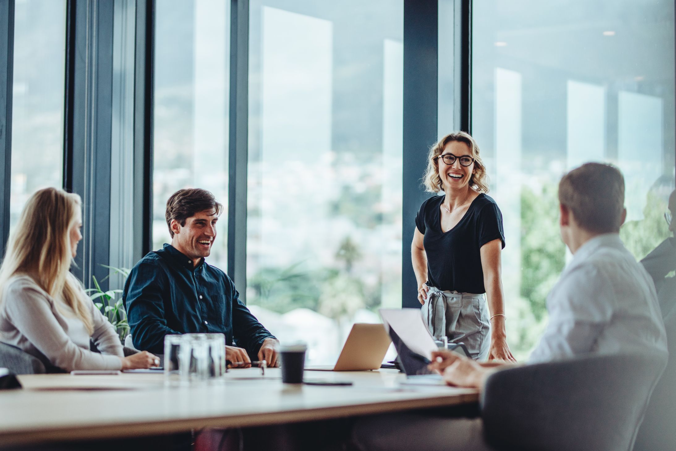 En gruppe mennesker i møterom som ler